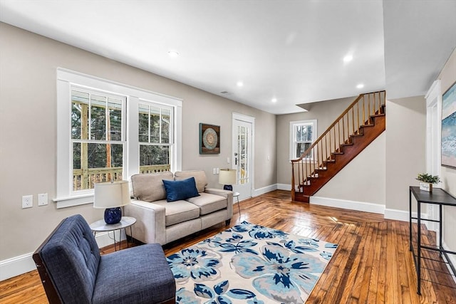 living area with a healthy amount of sunlight, recessed lighting, baseboards, and stairs