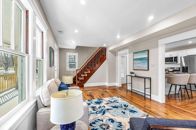 living room with baseboards, recessed lighting, stairway, visible vents, and wood finished floors