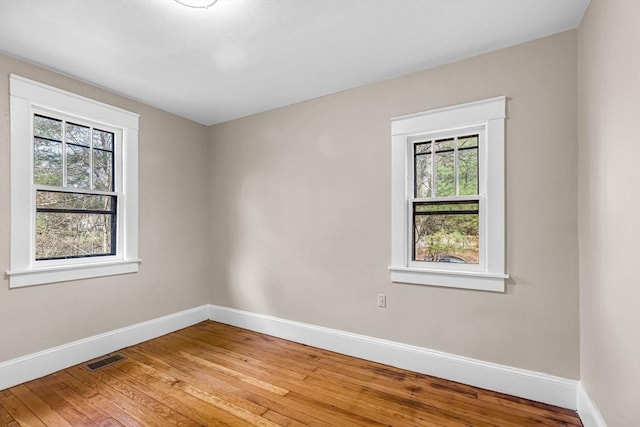 empty room featuring visible vents, baseboards, and a healthy amount of sunlight