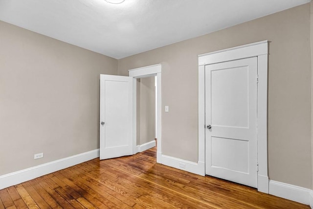 unfurnished bedroom featuring baseboards and hardwood / wood-style flooring