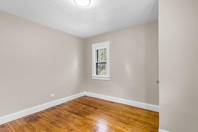 spare room with hardwood / wood-style flooring and baseboards