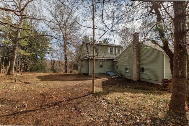back of property with a chimney