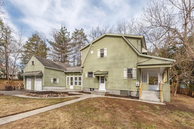 rear view of property featuring entry steps, a gambrel roof, and driveway
