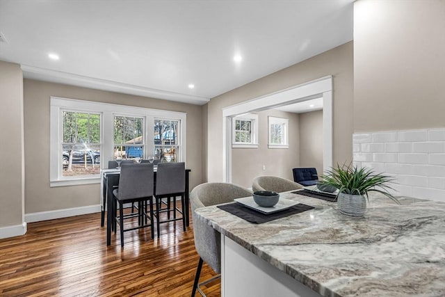 dining space with a wealth of natural light, recessed lighting, baseboards, and dark wood finished floors