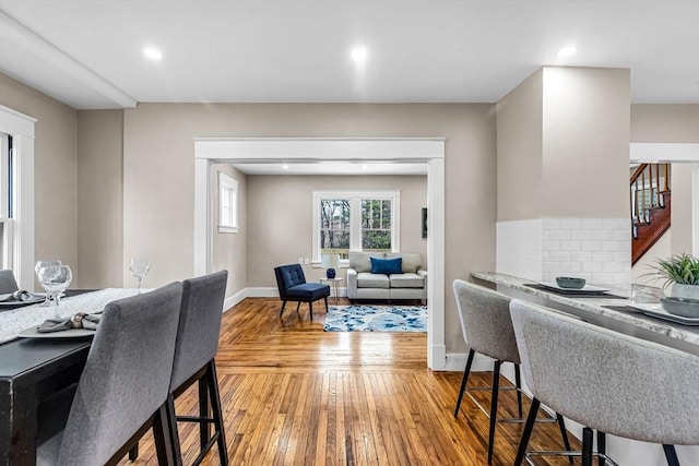 dining area with light wood-style flooring, recessed lighting, baseboards, and stairs