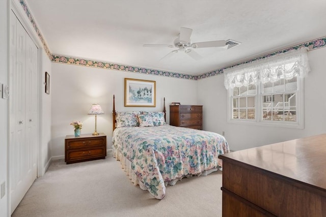 bedroom featuring light carpet, ceiling fan, and a closet