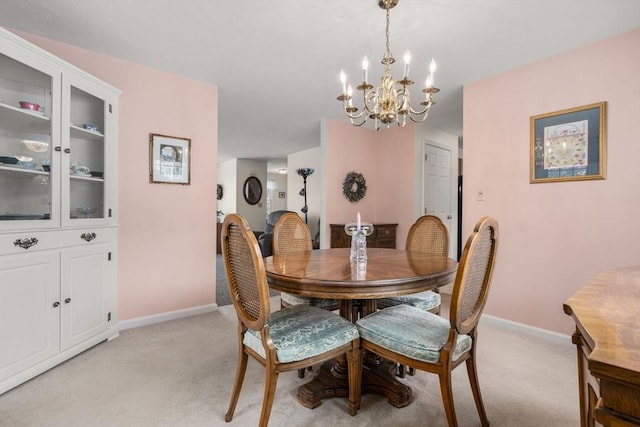 dining space with an inviting chandelier and light colored carpet