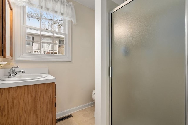 bathroom featuring vanity, an enclosed shower, and toilet