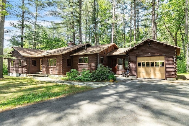 6 N St, Acton, MA 01720 - log cabin featuring an attached garage, log exterior, asphalt driveway, and a chimney
