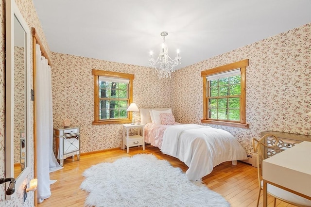 6 N St, Acton, MA 01720 - bedroom with wallpapered walls, wood finished floors, a chandelier, multiple windows, and a baseboard radiator