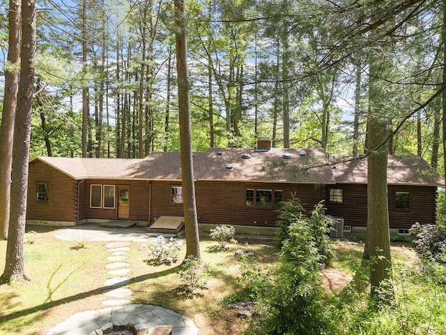6 N St, Acton, MA 01720 - back of property with an outdoor fire pit, a patio, log siding, and roof with shingles