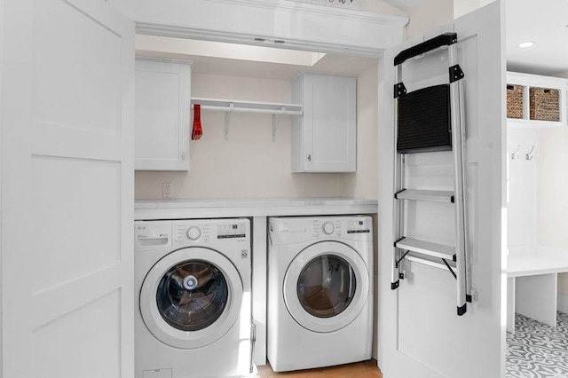 washroom with washing machine and clothes dryer and cabinet space