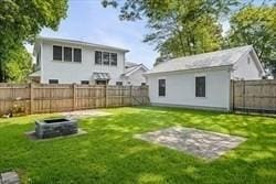 back of house with a fenced backyard, a yard, and an outdoor structure