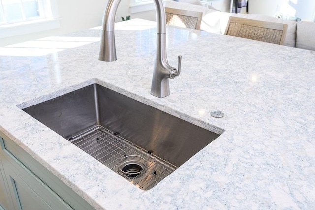 details with a sink and light stone countertops