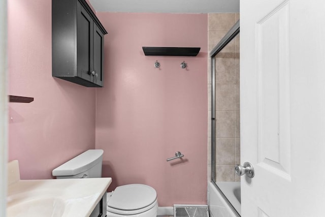 full bathroom featuring vanity, bath / shower combo with glass door, and toilet