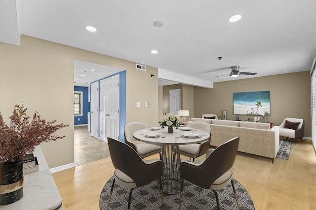 dining space with ceiling fan and light wood-type flooring