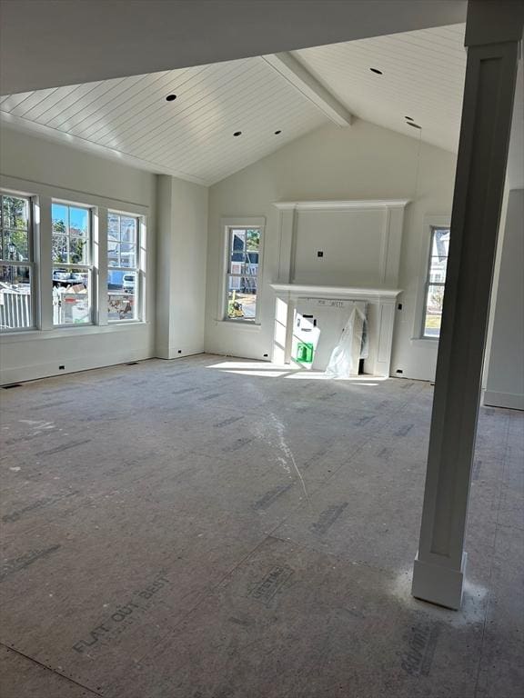 unfurnished living room featuring vaulted ceiling with beams