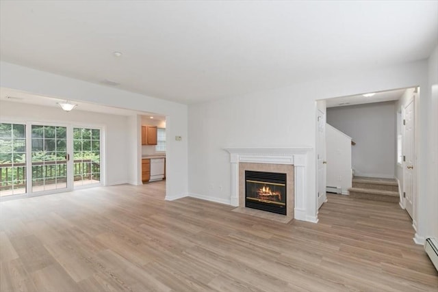 38 Abbey Rd Unit 38, Brentwood, NH 03833 - unfurnished living room featuring a tile fireplace, light wood finished floors, a baseboard heating unit, and stairs