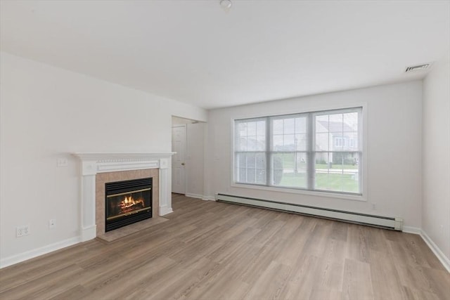 38 Abbey Rd Unit 38, Brentwood, NH 03833 - unfurnished living room with a baseboard radiator, light wood-style flooring, and a tiled fireplace