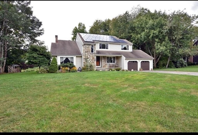 view of front of home featuring solar panels, a garage, and a front lawn