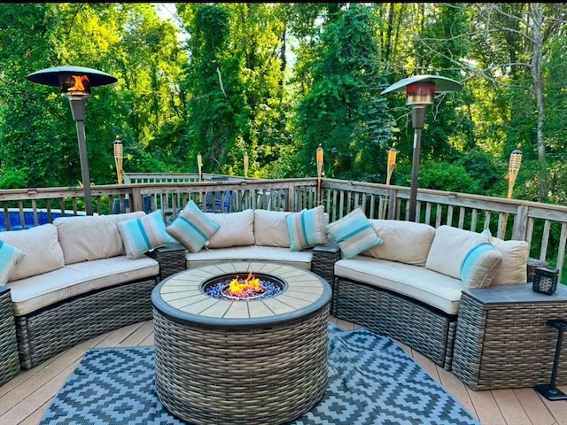 wooden terrace featuring an outdoor living space with a fire pit