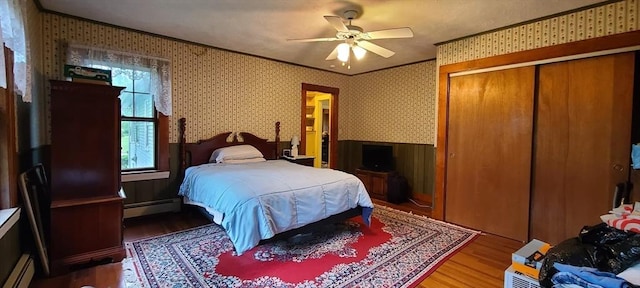 293 Cocasset St, Foxboro, MA 02035 - bedroom featuring baseboard heating, wood finished floors, wallpapered walls, ornamental molding, and a wainscoted wall