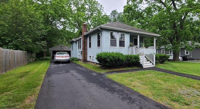 293 Cocasset St, Foxboro, MA 02035 - view of front facade featuring asphalt driveway, a chimney, an outbuilding, a porch, and a detached garage