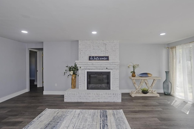 living room featuring recessed lighting, baseboards, wood finished floors, and a fireplace