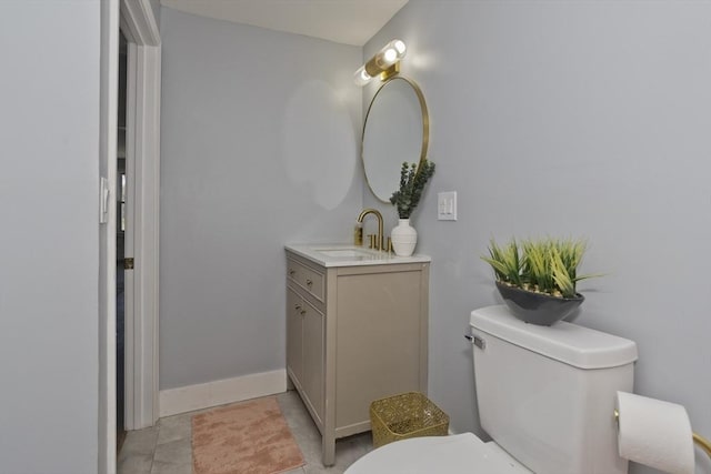 bathroom featuring vanity, baseboards, and toilet