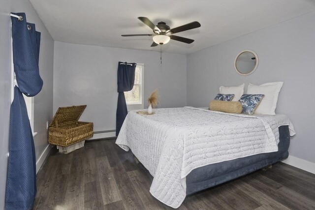 bedroom featuring a ceiling fan, baseboards, wood finished floors, and a baseboard radiator