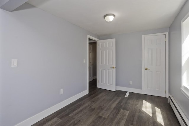 unfurnished bedroom featuring baseboards, a baseboard radiator, and dark wood finished floors