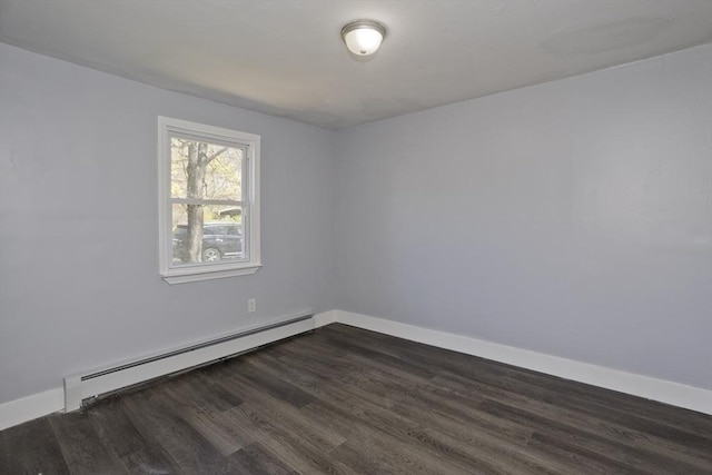 spare room featuring baseboards, baseboard heating, and dark wood-type flooring