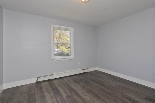 empty room featuring baseboards, dark wood finished floors, and a baseboard radiator