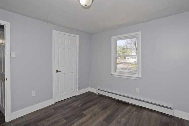 empty room featuring baseboards, baseboard heating, and dark wood-style floors