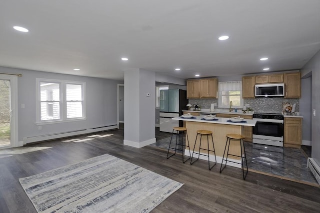 kitchen featuring freestanding refrigerator, dark wood-style floors, electric range oven, stainless steel microwave, and a baseboard radiator