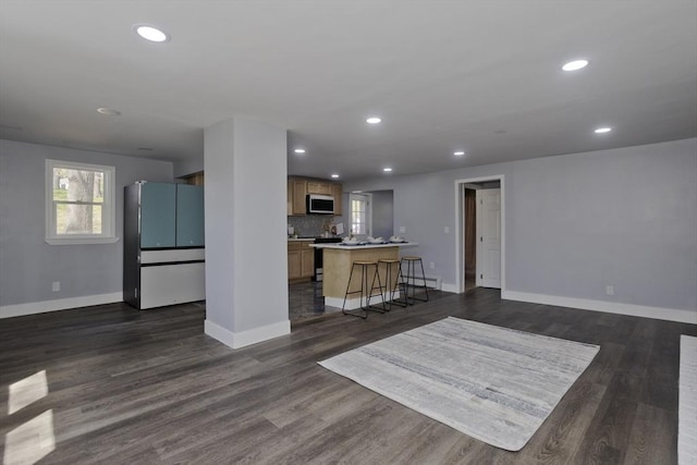 living area with baseboards, recessed lighting, and dark wood finished floors