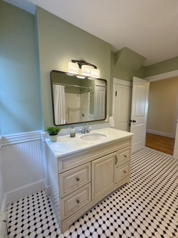 36-1/2 Pearl St Unit 36H, Milford, MA 01757 - bathroom with vanity, wainscoting, curtained shower, and tile patterned floors