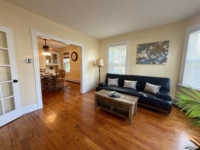 36-1/2 Pearl St Unit 36H, Milford, MA 01757 - living area featuring wood finished floors, plenty of natural light, baseboard heating, and ceiling fan