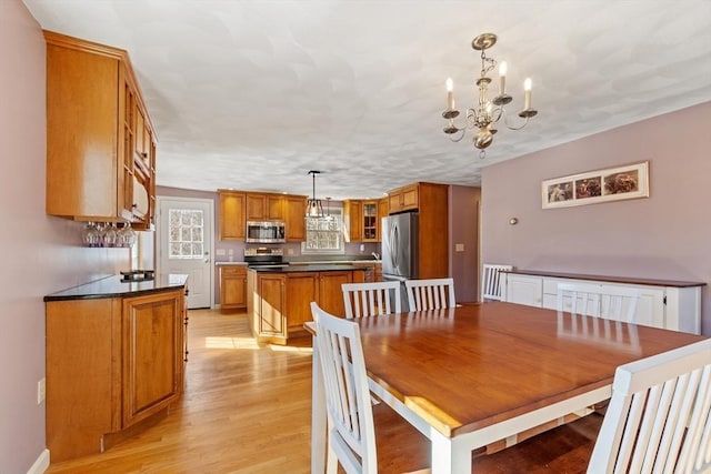 dining room with light wood finished floors and an inviting chandelier