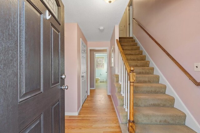 entrance foyer with stairway, baseboards, and light wood finished floors