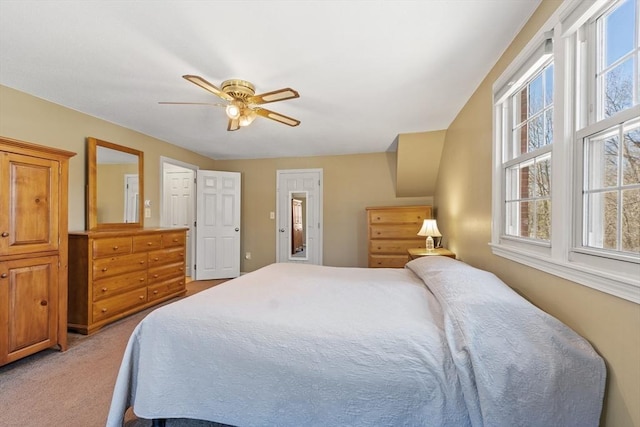 bedroom with multiple windows, a ceiling fan, and light carpet