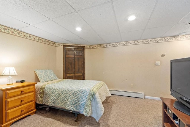 bedroom featuring baseboards, a baseboard heating unit, a paneled ceiling, and carpet floors