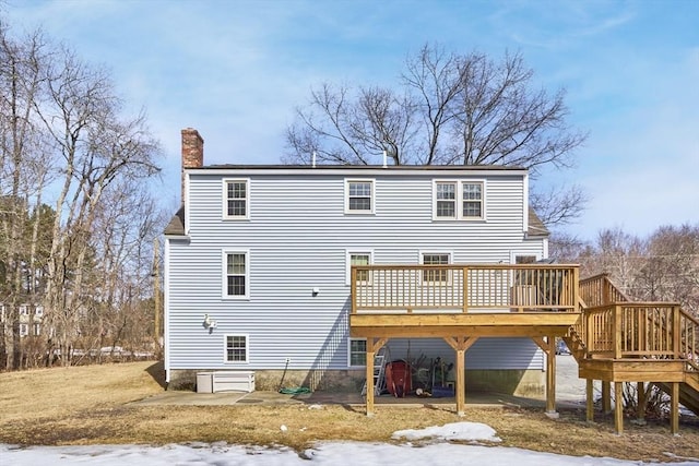 back of property featuring a wooden deck and a chimney