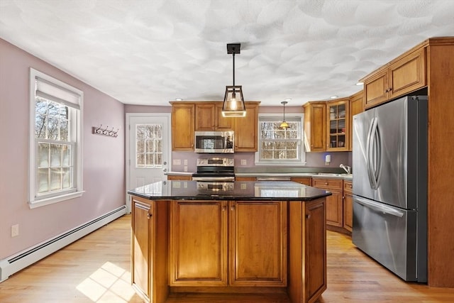 kitchen featuring baseboard heating, brown cabinets, and appliances with stainless steel finishes