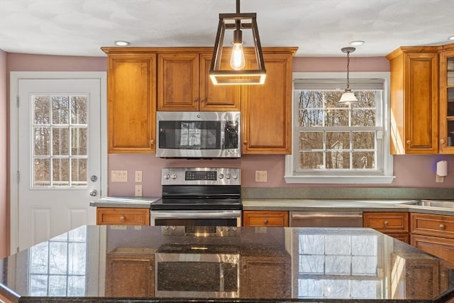 kitchen with a healthy amount of sunlight, brown cabinets, and appliances with stainless steel finishes