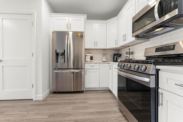 kitchen featuring white cabinets, decorative backsplash, light hardwood / wood-style floors, and appliances with stainless steel finishes