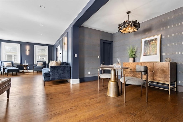 dining space with wood finished floors and a chandelier