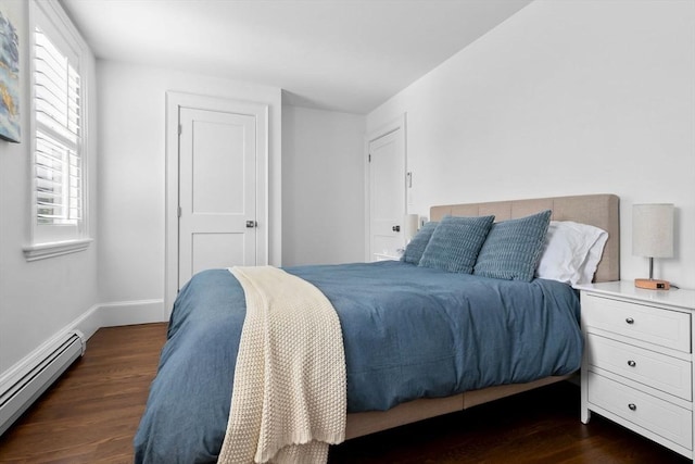 bedroom with baseboards, a baseboard radiator, and dark wood-type flooring