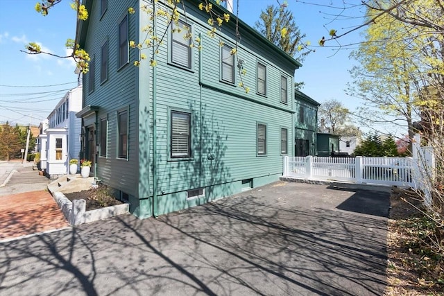 view of property exterior with a patio and fence