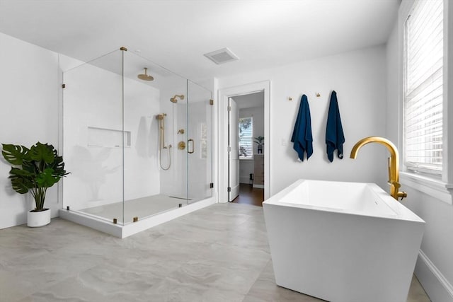 bathroom with a freestanding tub, visible vents, a shower stall, and a wealth of natural light
